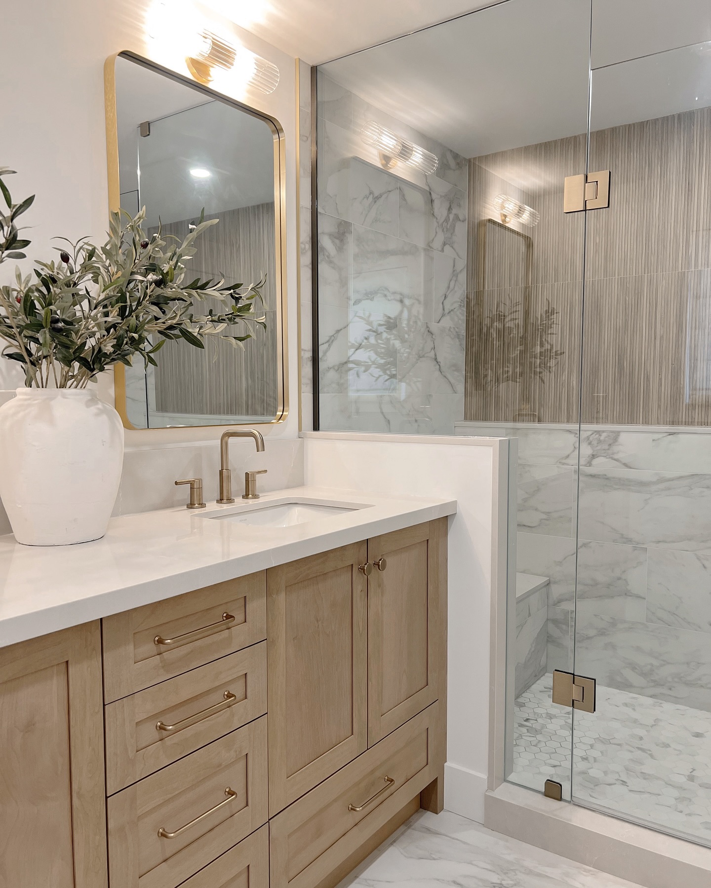 Bathroom remodel with white oak vanity, marble tile and a glass shower