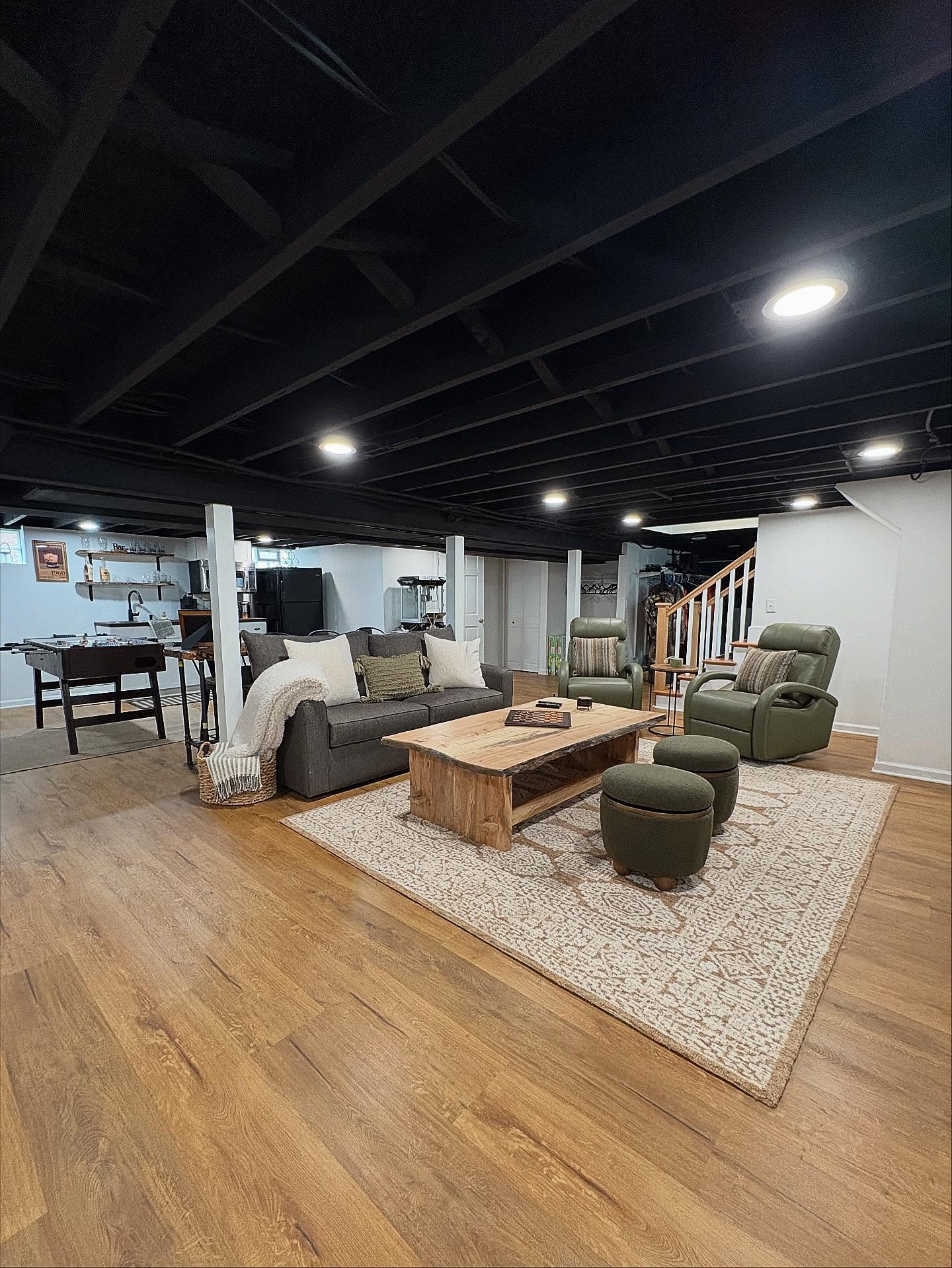Finished basement with painted open ceiling, bar area and lounge seating